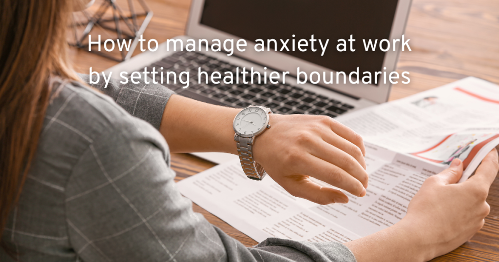 WOMAN SITTING AT A DESK WITH A LAPTOP AND A REPORT CHECKING HER WATCH AS A SIGNAL TO FINISH LEARNING HOW TO MANAGE HER ANXIETY AT WORK BY SETTING BOUNDARIES