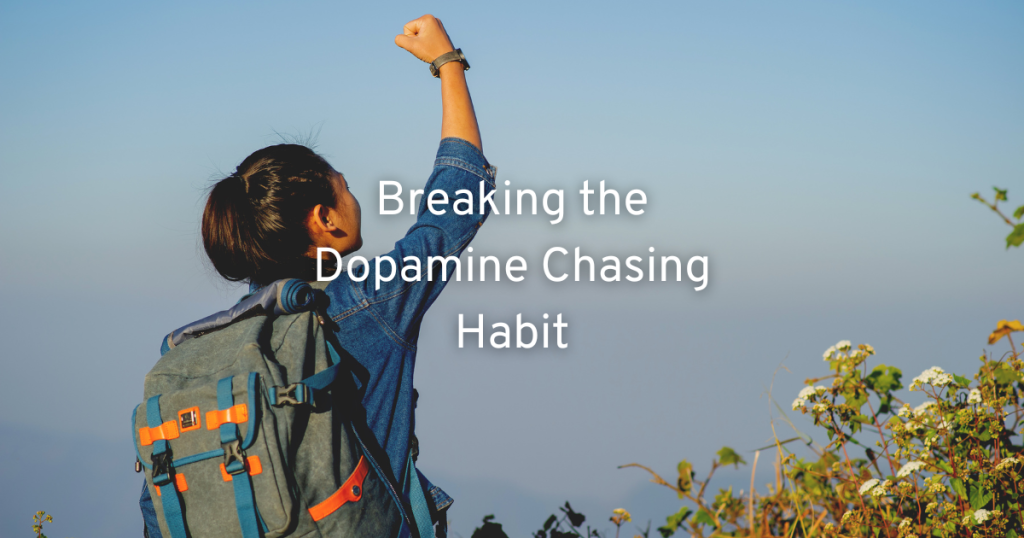 woman reaching the top of a hill with a rucksack on on a clear day fist pumping the air as she is breaking the dopamine chasing habit and getting it naturally instead