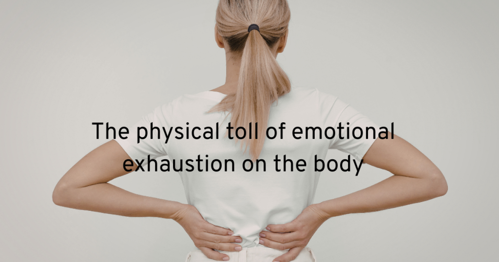 a woman with her back to us wearing all white clothes and her hair tied back holding the bottom of her back and showing us the physical toll of emotional exhaustion on the body